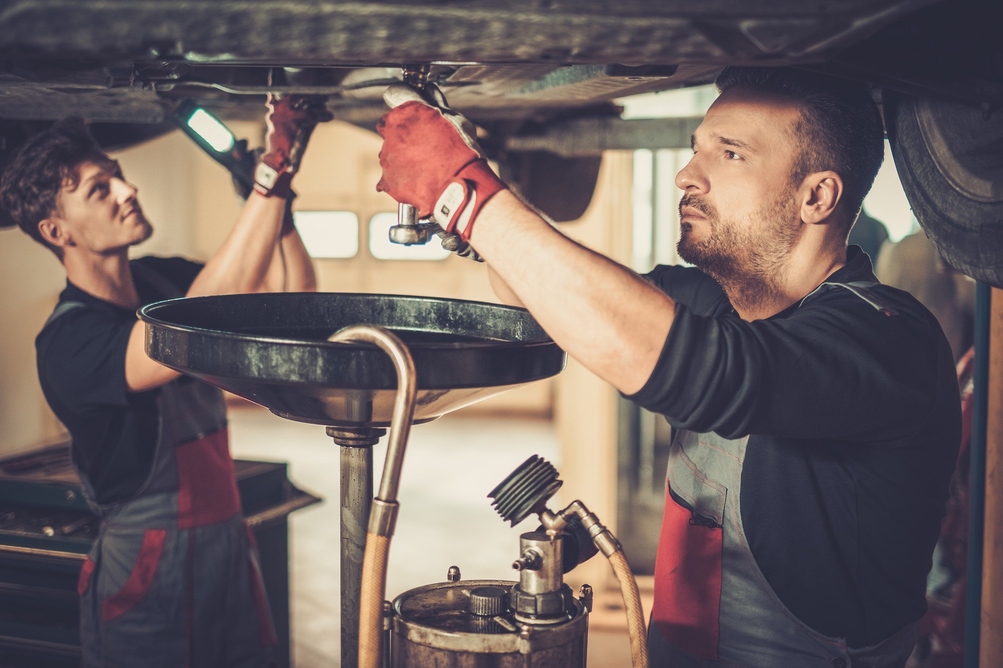 Garagistes changeant l'huile d'une voiture