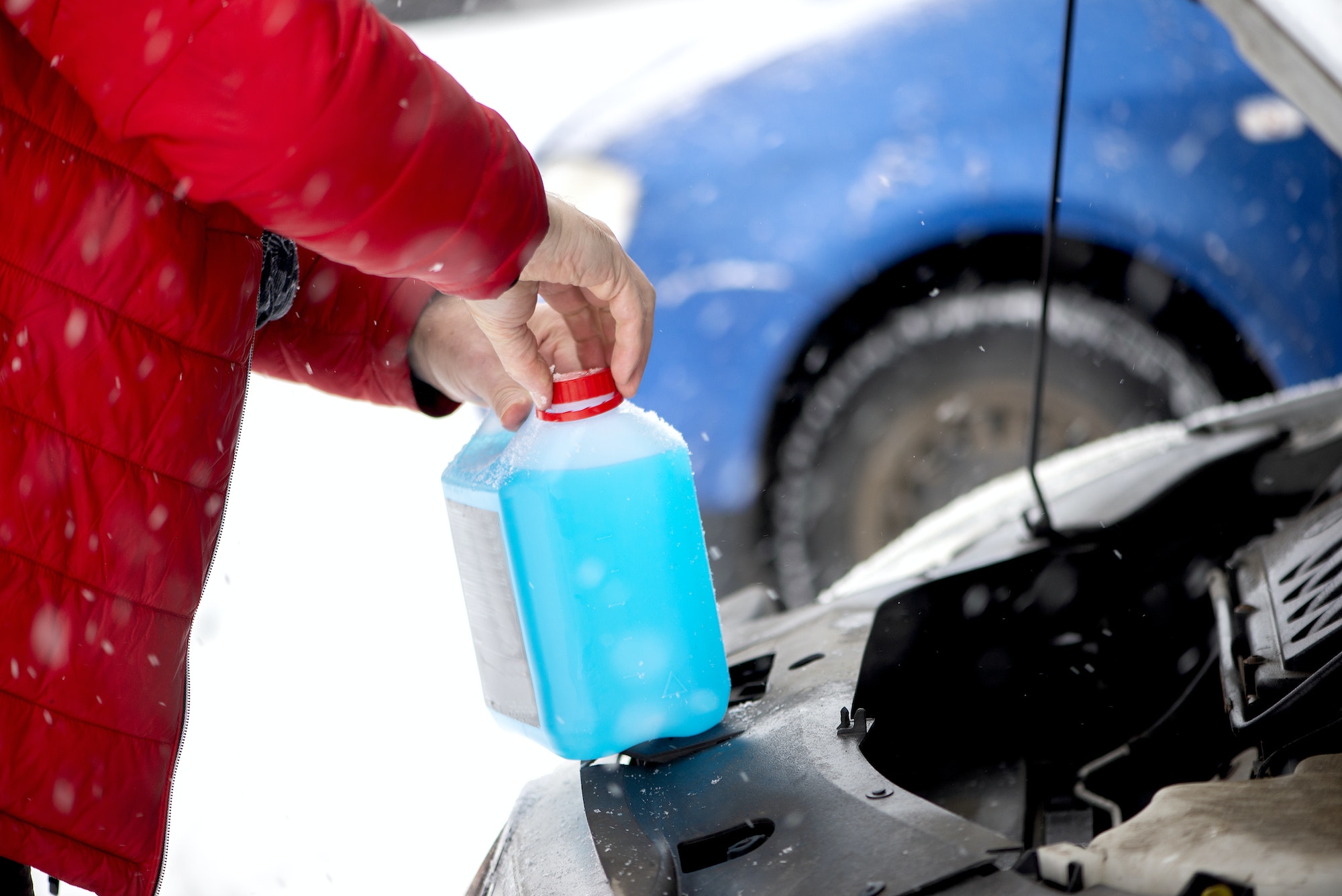 Homme remplissant l'antifreeze de la voiture