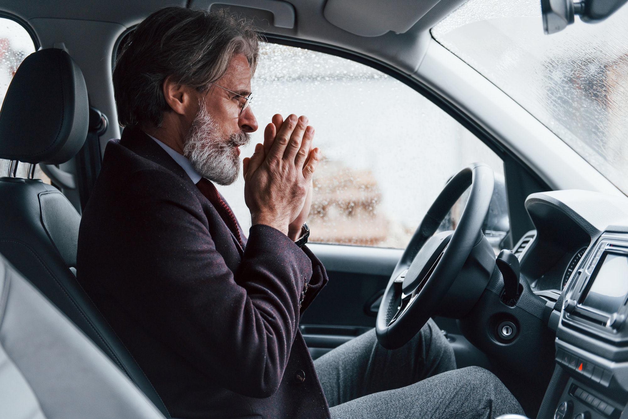 Homme dans la voiture ayant froid