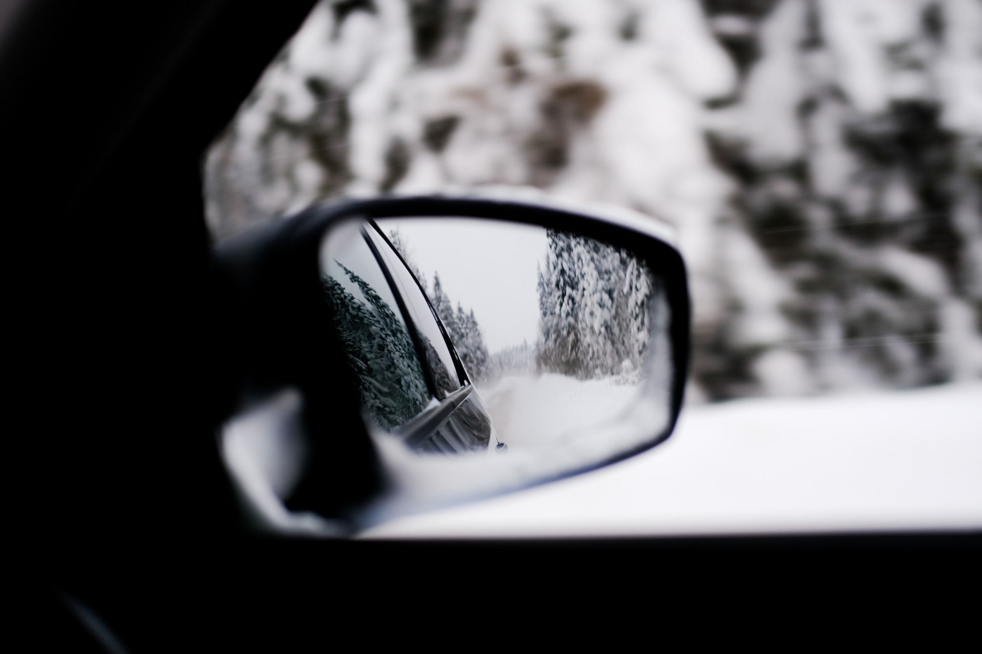 Paysage enneigé vu dans le rétro d'une voiture